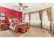 Spacious bedroom with wood bed frame, ceiling fan, and red accent wall at 30792 N Orange Blossom Cir, San Tan Valley, AZ 85143