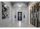 Elegant entryway with a wine cellar and modern light fixture at 33214 N 14Th St, Phoenix, AZ 85085