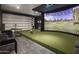 Indoor golf simulator room, complete with a large screen and putting area at 33214 N 14Th St, Phoenix, AZ 85085