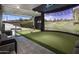 Indoor golf simulator with a putting green and seating area at 33214 N 14Th St, Phoenix, AZ 85085