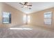 Spacious bedroom featuring ceiling fan and multiple windows at 34403 N Damietta Trl, San Tan Valley, AZ 85143