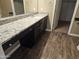 Bathroom boasts granite countertop, dark wood cabinets, and vinyl flooring at 36850 W Nola Way, Maricopa, AZ 85138