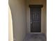 Front entrance with a dark brown door and a small covered porch at 36850 W Nola Way, Maricopa, AZ 85138