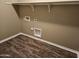 Laundry room with wood-look vinyl flooring and shelving at 36850 W Nola Way, Maricopa, AZ 85138