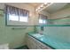 Bathroom features mint green tile and a vanity with storage at 3809 E Highland Ave, Phoenix, AZ 85018