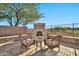 Stone patio with wicker chairs and small table near fireplace at 40610 N Bradon Ct, Phoenix, AZ 85086