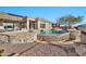 Relaxing pool and spa with stonework and red chairs at 40610 N Bradon Ct, Phoenix, AZ 85086