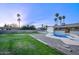 Relaxing pool area with diving board, grassy area, and palm trees at 413 W Marco Polo Rd, Phoenix, AZ 85027