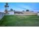 Large grassy backyard with a home, privacy wall, and palm trees at 413 W Marco Polo Rd, Phoenix, AZ 85027