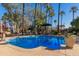 Inviting community pool with surrounding palm trees and lounge chairs at 4540 N 44Th St # 69, Phoenix, AZ 85018