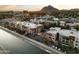 Aerial view of modern condos near canal, mountain backdrop at 4805 N Woodmere Fairway Ln # 1012, Scottsdale, AZ 85251