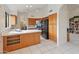 Modern kitchen with wood cabinets, black appliances, and an island with wine rack at 5025 E Waltann Ln, Scottsdale, AZ 85254