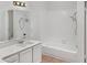 Clean bathroom with white tiled walls, bathtub and vanity at 5036 W Gelding Dr, Glendale, AZ 85306