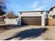 Brown double-door garage with a long driveway at 5036 W Gelding Dr, Glendale, AZ 85306