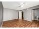 Bedroom with wood floors, ceiling fan, and access to bathroom at 5715 W Heatherbrae Dr, Phoenix, AZ 85031