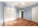 Bedroom with wood-look floors, double door closet and ceiling fan at 5715 W Heatherbrae Dr, Phoenix, AZ 85031