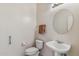 Powder room with pedestal sink, toilet, and circular mirror at 5950 E Lowden Ct, Cave Creek, AZ 85331