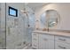 Modern bathroom with a walk-in shower, white vanity, and marble tile at 6406 E Helm Dr, Scottsdale, AZ 85254