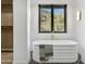 Relaxing bathroom with freestanding tub, brick accent wall and a view at 8200 N Charles Dr, Paradise Valley, AZ 85253