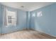 Light blue bedroom with wood-look floors and window at 8841 W Cordes Rd, Tolleson, AZ 85353