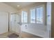 Bathroom features a shower, bathtub, and window with shutters at 10406 E Laguna Azul Ave, Mesa, AZ 85209