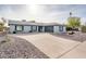 Single story home with gray roof, white painted brick, and a long driveway at 11225 S Tomah St, Phoenix, AZ 85044