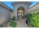 Elegant entryway with arched entry, stone tile flooring, and lush landscaping at 12657 N 135Th St, Scottsdale, AZ 85259