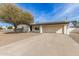 Front view of a ranch home with solar panels and a large gravel driveway at 13235 N 24Th Ave, Phoenix, AZ 85029