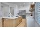 Eat-in kitchen island with white quartz countertops and light wood cabinets at 1604 E Sheena Dr, Phoenix, AZ 85022