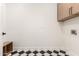 Laundry room with wood cabinets and black and white floor at 16446 N 56Th Way, Scottsdale, AZ 85254