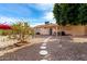 Landscaped backyard with a stone pathway, mature trees, and a covered patio at 1724 W 15Th Ave, Apache Junction, AZ 85120