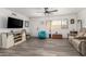 Living room with wood-look floors, teal accent chair, and large TV at 1724 W 15Th Ave, Apache Junction, AZ 85120