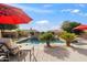 Inviting backyard oasis featuring a sparkling pool and red umbrellas at 1805 W Parnell Dr, Phoenix, AZ 85085