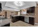 Modern kitchen with dark cabinetry, granite counters, and stainless steel appliances at 18625 N 103Rd Ave, Sun City, AZ 85373