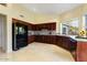 Well-equipped kitchen with dark wood cabinets and black appliances at 18903 N 87Th Dr, Peoria, AZ 85382