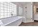 Elegant bathroom with soaking tub, walk-in shower, and glass block windows at 19034 N 94Th Way, Scottsdale, AZ 85255