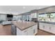 Modern kitchen with white cabinets, large island, and views of the living room at 19034 N 94Th Way, Scottsdale, AZ 85255