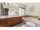 Bathroom with double sinks, wood cabinets, and a large bathtub at 1918 E Hearn Rd, Phoenix, AZ 85022