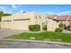 A beige home showing the garages and the lawns with green shrubbery at 2059 E Brown Rd # 23, Mesa, AZ 85213