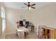 Home office with wood-look tile flooring, ceiling fan, and bright light from the window at 2059 E Brown Rd # 23, Mesa, AZ 85213