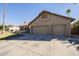 Tan two-car garage with paved driveway and mature landscaping at 2265 E Mallard Ct, Gilbert, AZ 85234