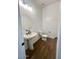 Modern powder room with pedestal sink and wood-look floors at 22910 E Alyssa Rd, Queen Creek, AZ 85142