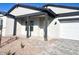 Home's exterior features a covered porch, dark gray pillars, and a two-car garage at 22910 E Alyssa Rd, Queen Creek, AZ 85142