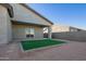 Artificial turf backyard with a covered patio and gray block wall at 34909 N Palm Dr, San Tan Valley, AZ 85140