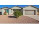 House exterior with gray walls, two-car garage, and a landscaped front yard at 34909 N Palm Dr, San Tan Valley, AZ 85140