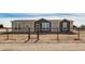 Tan and dark brown single-story house with a gated fence at 36747 W Harrison St, Tonopah, AZ 85354