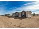 Rear view of a single-story home with a sandy yard at 36747 W Harrison St, Tonopah, AZ 85354