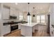 Modern kitchen with white cabinets, island, and stainless steel appliances at 36747 W Harrison St, Tonopah, AZ 85354