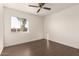 Bright bedroom with dark wood floors and a ceiling fan at 3744 W Malapai Dr, Phoenix, AZ 85051