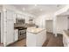 Bright kitchen with white cabinets, granite island, and stainless steel appliances at 3744 W Malapai Dr, Phoenix, AZ 85051